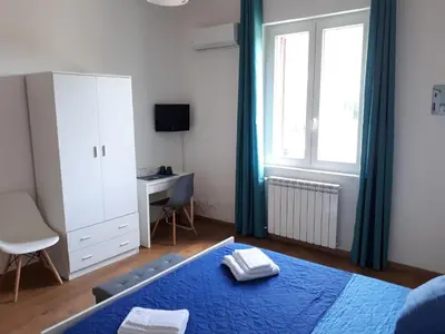 a bedroom with a bed and a desk and a window at Mondello Sicily House in Mondello