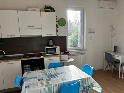 a kitchen with a table with blue chairs and a stove at Mondello Sicily House in Mondello