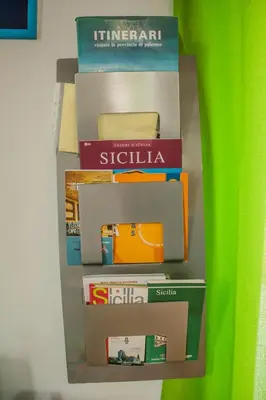a stack of books sitting on a shelf at Mondello Sicily House in Mondello