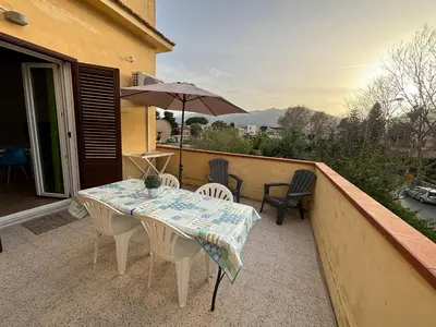 a table and chairs on a balcony with an umbrella at Mondello Sicily House in Mondello