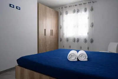 a bedroom with two white towels on a blue bed at A Mare Appartamenti in Castellammare del Golfo