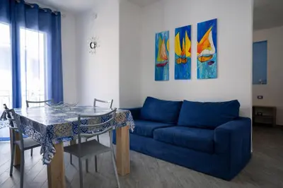 a living room with a blue couch and a table at A Mare Appartamenti in Castellammare del Golfo