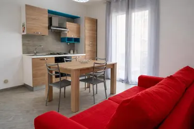 a living room with a table and a red couch at A Mare Appartamenti in Castellammare del Golfo