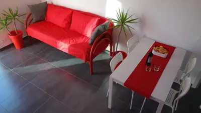 a living room with a red couch and a table at Casamatta in Trappeto