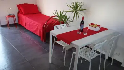 a white table and chairs with a bottle of wine at Casamatta in Trappeto