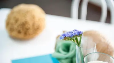 a vase with a flower in it on a table at Blue Suite in Castellammare del Golfo