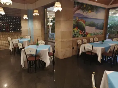 a dining room with blue tables and chairs and a painting at Mondello Addaura Home Holiday in Mondello