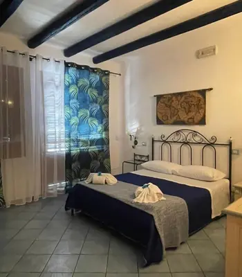 a bedroom with two beds and a window at Hellas Makari B&B in San Vito lo Capo