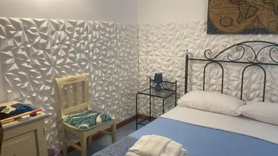 a bedroom with a bed and a chair in it at Hellas Makari B&B in San Vito lo Capo