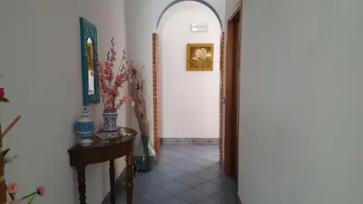 a hallway with an archway and some vases on a table at Hellas Makari B&B in San Vito lo Capo