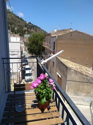 a potted plant sitting on a wooden balcony at Carpe Diem Apartments in Castellammare del Golfo