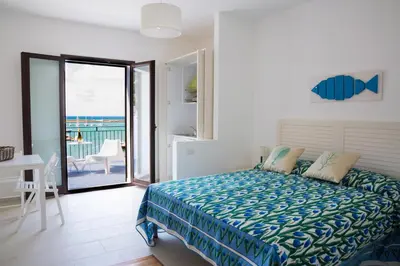a bedroom with a bed and a view of the ocean at N'amuri Residence in Castellammare del Golfo