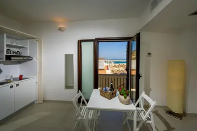 a kitchen and dining room with a table and chairs at N'amuri Residence in Castellammare del Golfo