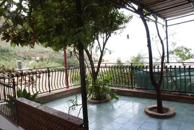 a balcony with two trees and a fence at Aura Maris in Castellammare del Golfo