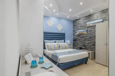 a bedroom with a king sized bed and a desk at Hotel Soffio D'Estate in San Vito lo Capo
