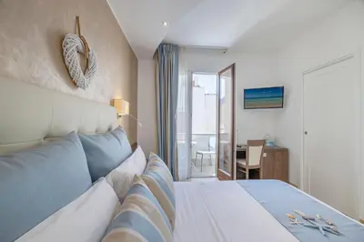 a hotel room with a bed and a view of a table at Hotel Soffio D'Estate in San Vito lo Capo