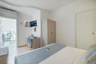a bedroom with a bed and a desk in it at Hotel Soffio D'Estate in San Vito lo Capo