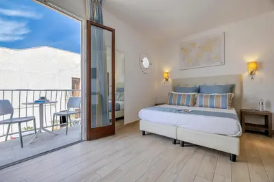 a bedroom with a bed and a balcony at Hotel Soffio D'Estate in San Vito lo Capo
