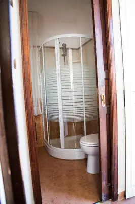 a bathroom with a toilet and a glass shower at Villa Buonasera in Santa Flavia