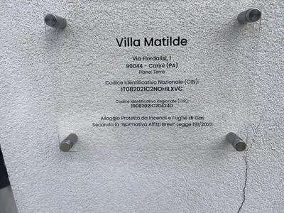 a sign on the side of a white wall at Villa Matilde in Carini