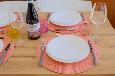a table with plates and forks and wine glasses at La Casa delle Ginestre in Alcamo Marina