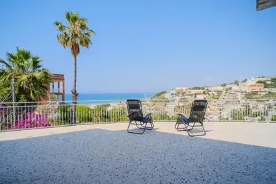 two chairs sitting on the beach with a view of the ocean at La Casa delle Ginestre in Alcamo Marina