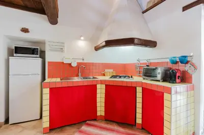 a kitchen with red and yellow cabinets and a sink at Villa 'Antico Baglio' - Scopello - Castellammare Del Golfo in Castellammare del Golfo
