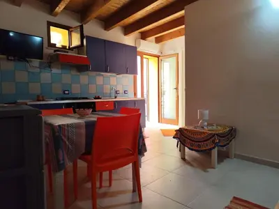 a kitchen with a table and red chairs and a table sidx sidx sidx at La Marina in Castellammare del Golfo