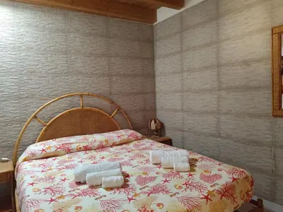 a bedroom with a bed with two candles on it at La Marina in Castellammare del Golfo