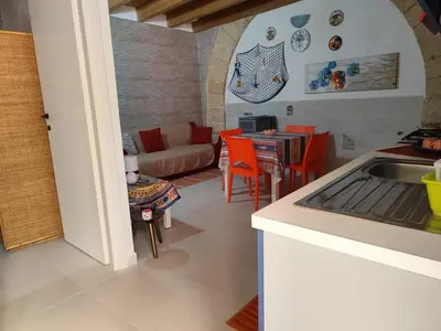 a kitchen and living room with a couch and a table at La Marina in Castellammare del Golfo