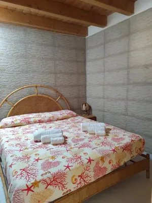 a bedroom with a bed with a floral bedspread at La Marina in Castellammare del Golfo
