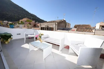 a balcony with a table and chairs on a roof at Palazzo Taormina in Castellammare del Golfo