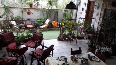 a patio with tables and chairs and potted plants at La Palma San Francesco in Sferracavallo