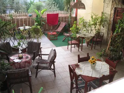 a patio with tables and chairs and a fence at La Palma San Francesco in Sferracavallo