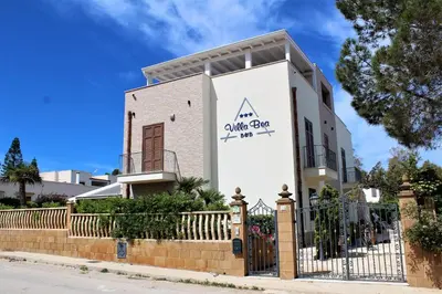 a white building with a fence in front of it at B&B Villa Bea in San Vito lo Capo