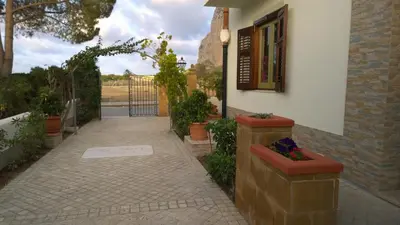 a walkway leading to a house with a window and flowers at B&B Villa Bea in San Vito lo Capo