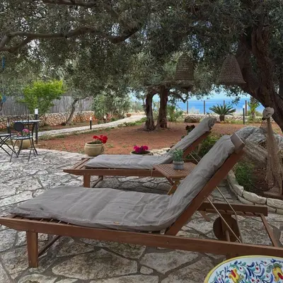 a hammock and a table under a tree at Villa Cala Bianca in Castellammare del Golfo