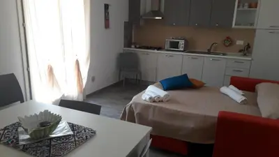 a kitchen with a table and a bed in a room at Il Bambu' in San Vito lo Capo