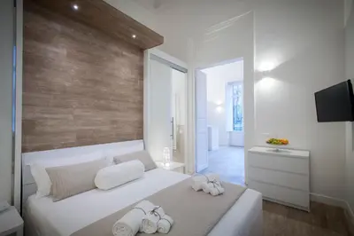 a bedroom with a white bed with towels on it at Politeama Apartments by Giorgio in Palermo