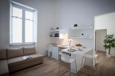 a kitchen and living room with a couch and a table at Politeama Apartments by Giorgio in Palermo