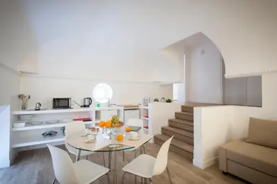 a kitchen and living room with a table and chairs at Politeama Apartments by Giorgio in Palermo