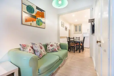 a living room with a green couch and a dining room at Casa Nonna Toto in Palermo
