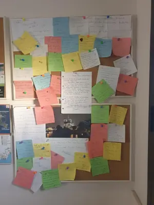 a bulletin board with lots of sticky notes at Le Casette in Santa Flavia