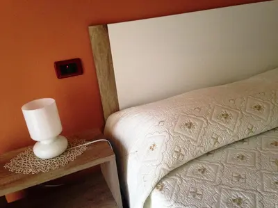 a bedroom with a bed and a lamp on a table at La Casa Di Tufo in Palermo