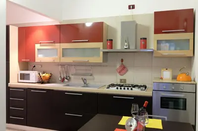 a kitchen with brown cabinets and a stove top oven at La Casa Di Tufo in Palermo