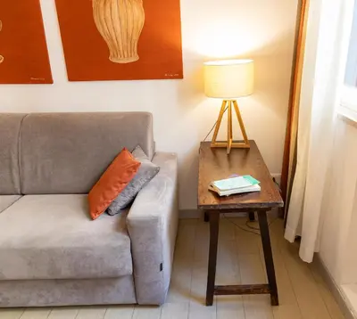 a living room with a couch and a table with a lamp at Loggiato 261 Palazzo San Matteo in Palermo