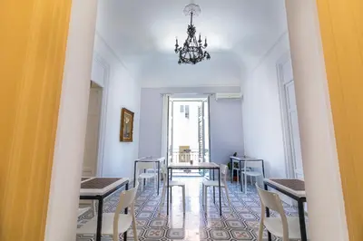 a dining room with tables and chairs and a chandelier at Liberty Suites in Palermo