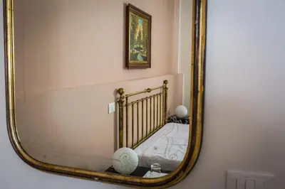 a mirror on a wall with a bed in a room at Liberty Suites in Palermo