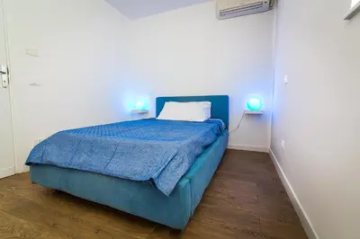 a bedroom with a blue bed and two lamps at Liberty Suites in Palermo