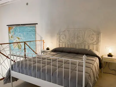 a bedroom with a bed and a map on the wall at Nelle Antiche Mura in Castellammare del Golfo